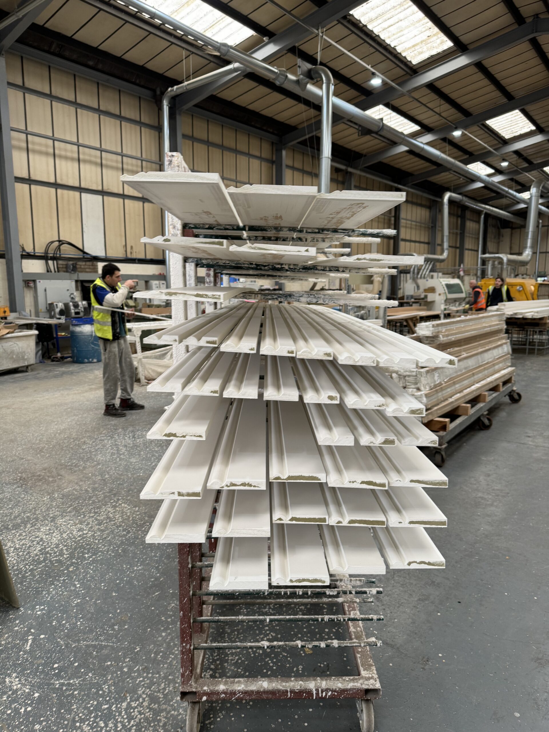 Freshly primed skirting boards being quality checked in our factory